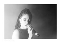 Black-and-white photograph of Elodie in concert at the Circolo Magnolia in Segrate; a close-up of the artist with half her face illuminated and half in shadow, in a fine art chiaroscuro style.