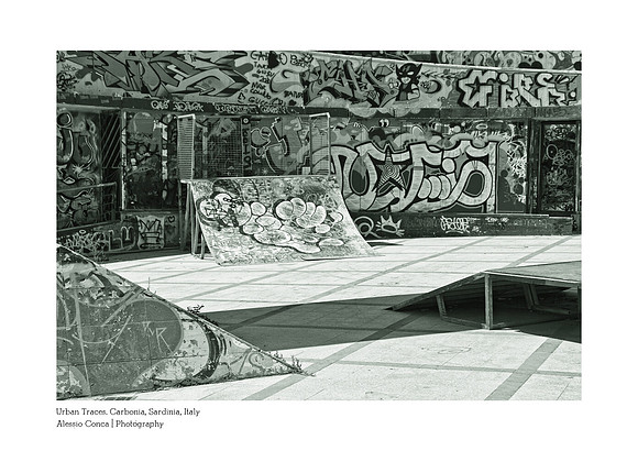 Artistic black-and-white photography that highlights the contrasts of street art in the urban landscape of Carbonia, Sardinia.
