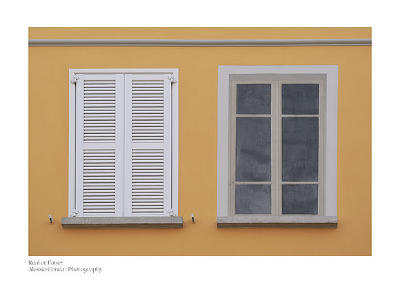 Color fine art photograph of two windows side by side: a real window with white shutters and a painted window. Concept: Real or Fake.