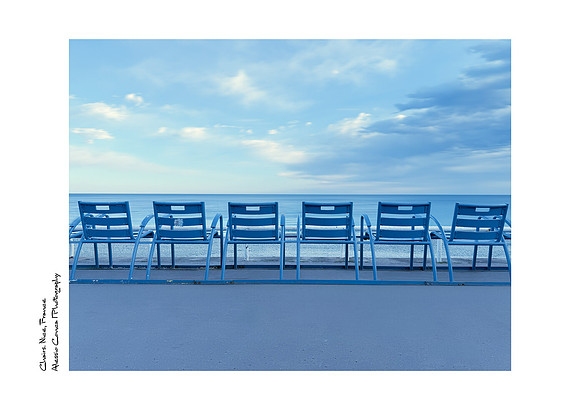 Fine Art Print of the iconic blue chairs along the Nice seafront with blue skies and clouds, great for offices and modern decor.